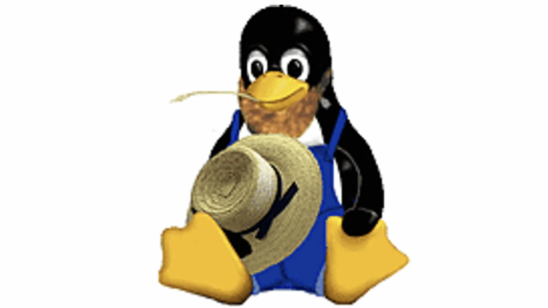 The Linux penguin sitting down while wearing overalls and holding a straw hat